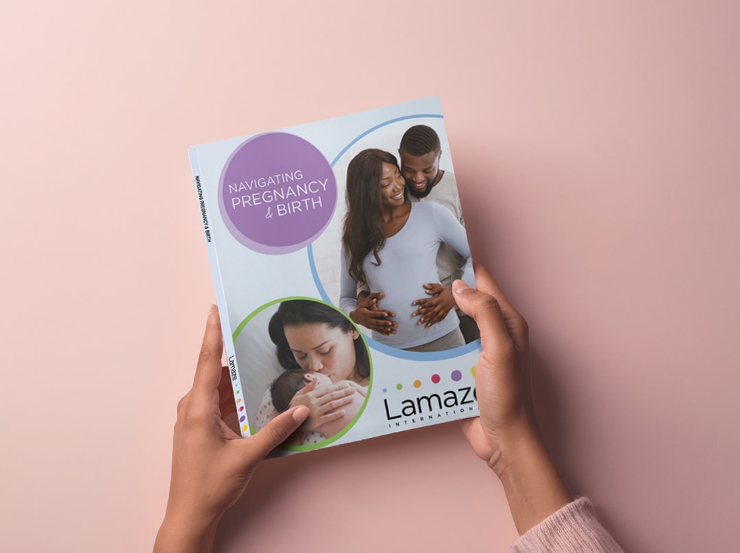 Hands holding the Lamaze Navigating Pregnancy & Birth guidebook